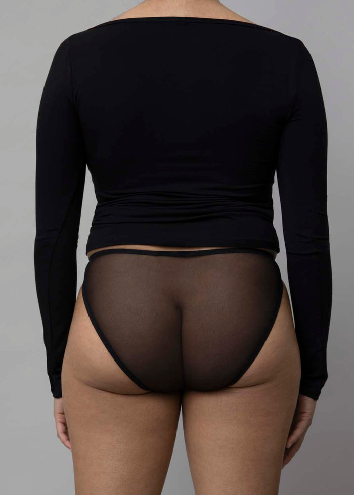 Back view of a model wearing Kye Recline Bateau Long Sleeve, a black bamboo boat neckline long sleeve tee.