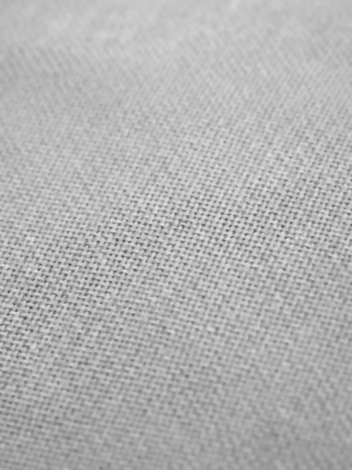 Close-up of grey trenchcoat fabric showing fine textured weave for detail and quality.