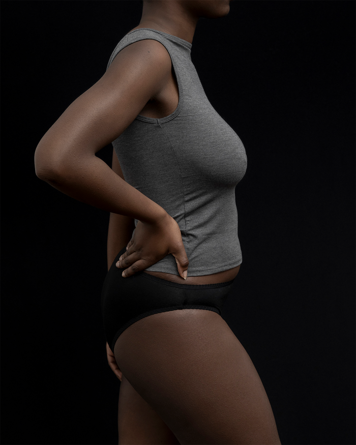 Side view of a model wearing Kye Recline bateau sleeveless in heathered charcoal. The breathable bamboo fabric provides comfort and style, perfect for everyday wear by Kye Intimates.