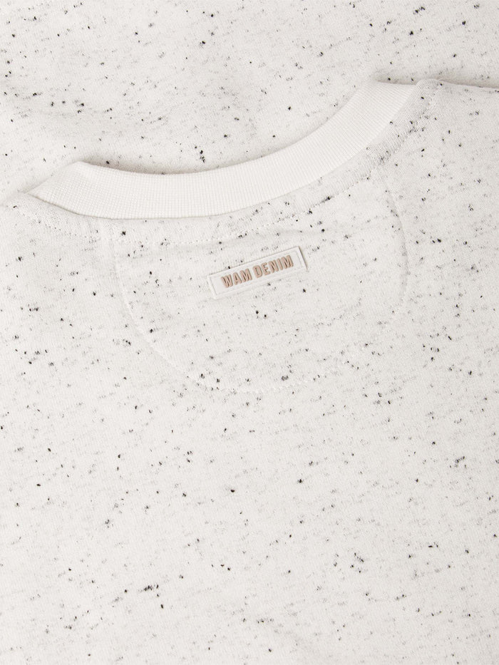 Speckled white sweater with a brand label on a white background