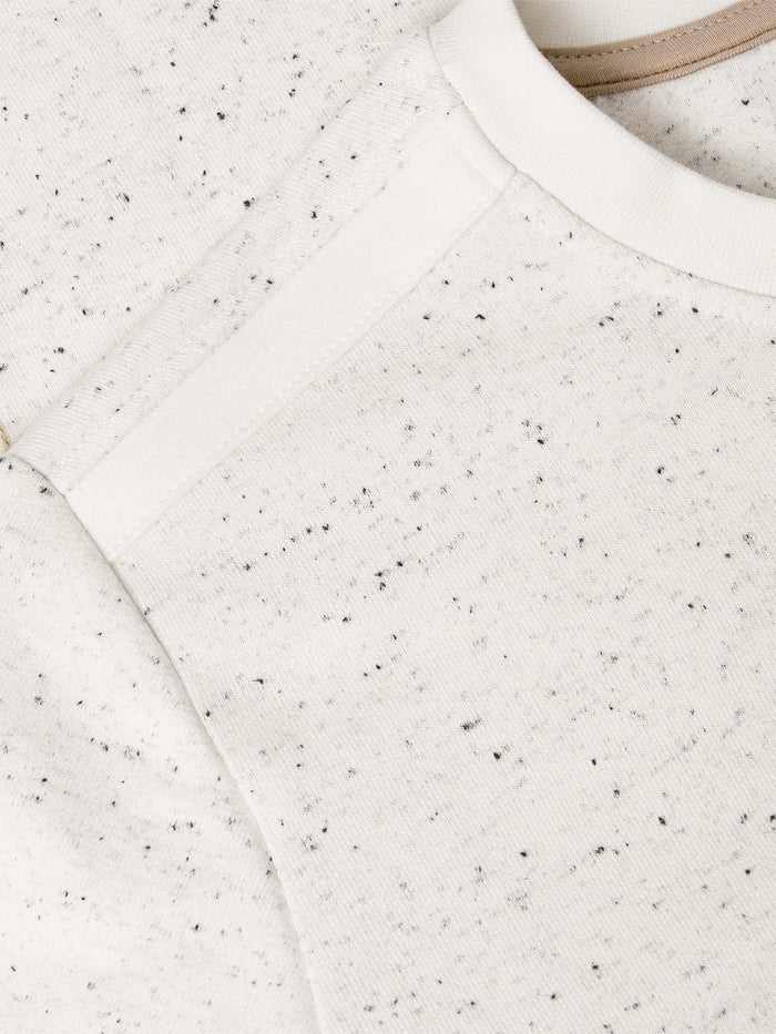 Close-up of a textured white fabric with black specks