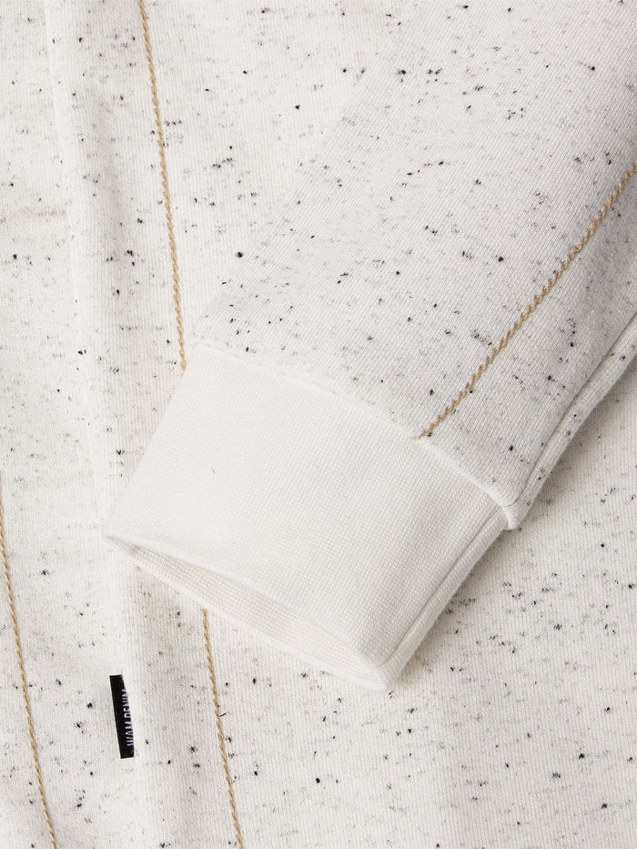 Close-up of a textured white fabric with black specks on a Off White background