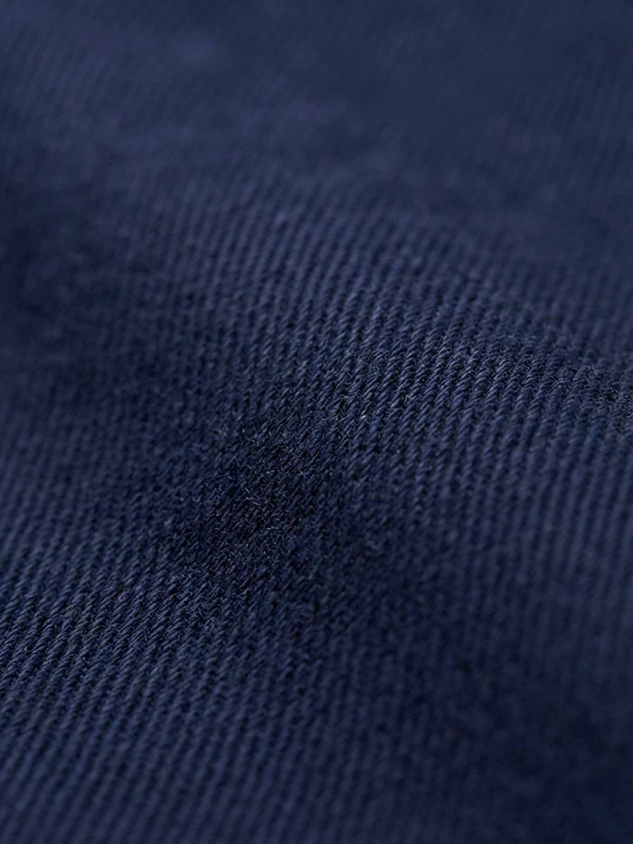 Close-up of navy denim fabric showing smooth weave and premium texture