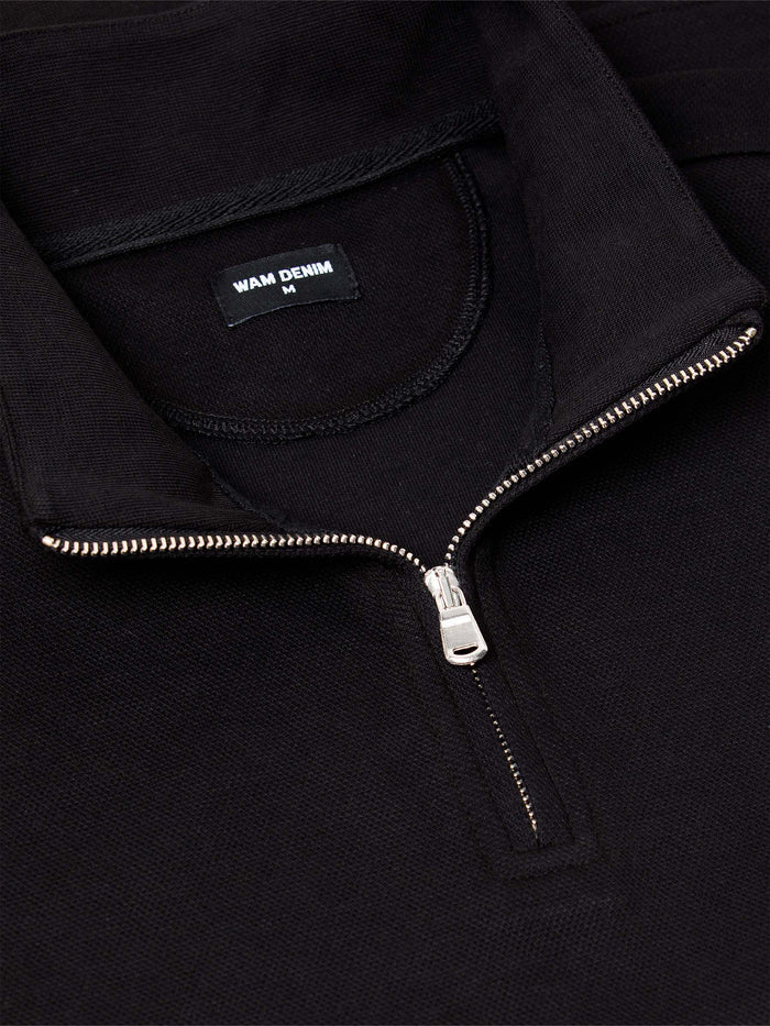 Close-up of black quarter-zip sweater with silver zipper and soft knit collar – Wam Denim.
