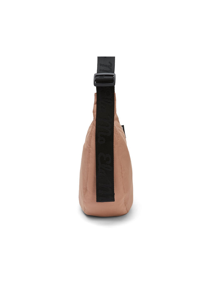 Ela Mo™ Moon Bag | Cocoa. Rosafarbene Umhängetasche von der Seite, mit schwarzem, verstellbarem Schulterriemen.