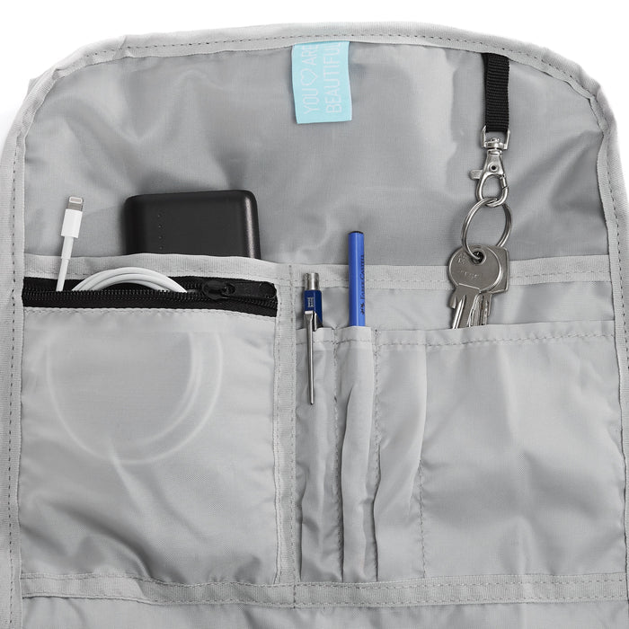 Ela Mo™ Rolltop Rucksack | Lavender. Hellgrauer Innenbereich des Rucksacks mit mehreren Fächern und Alltagsgegenständen.