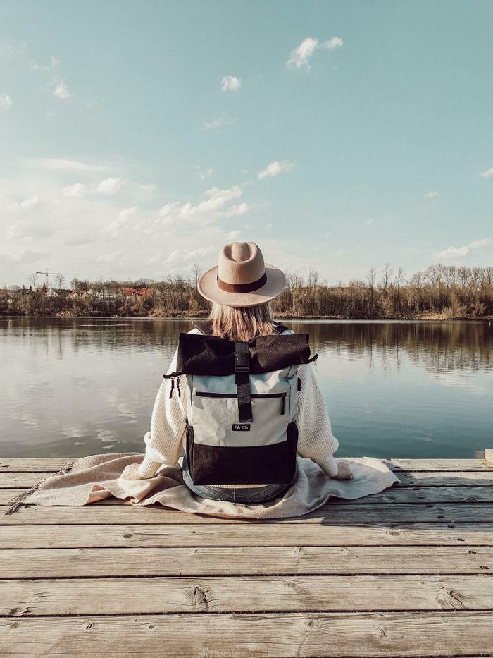 Ela Mo™ Rolltop Rucksack | The Grey. Eine Frau mit dem Rucksack auf dem Rücken – alltäglicher Lifestyle.