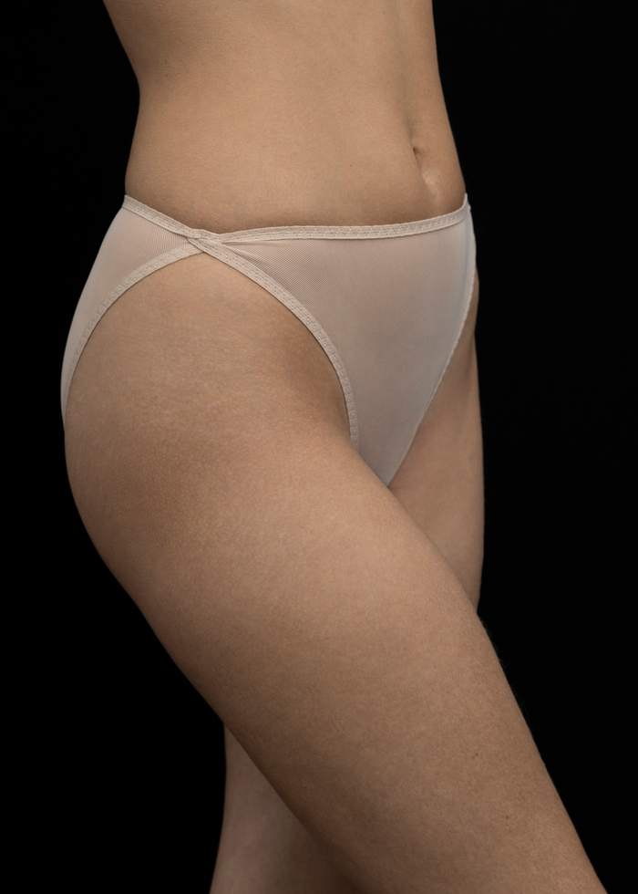 Model wearing Kye Intimates Mies Brief, a beige mesh high cut leg mid-rise brief in a neutral tone.