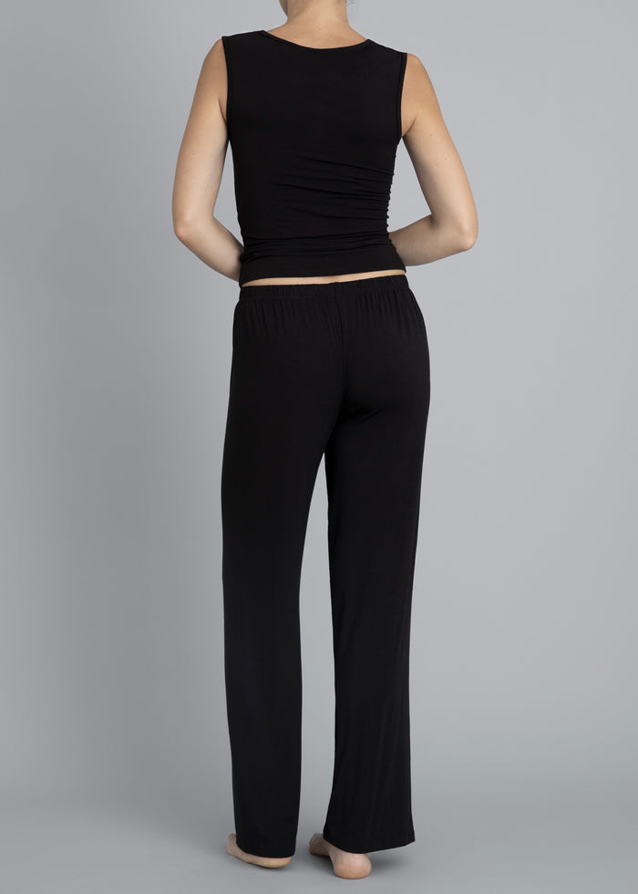 Back view of a model wearing Kye Recline Pant bamboo long pants in black. The pants feature a comfortable elastic waistband and a loose, flowy design, showcasing Kye Intimates’ commitment to comfort and style.