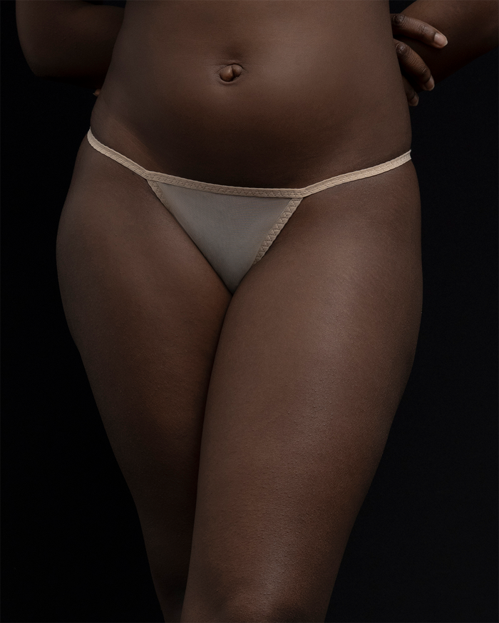 A zoomed in view of the Kye Intimates standard thong in the color ecru. Sheer underwear with barely there, minimal coverage.