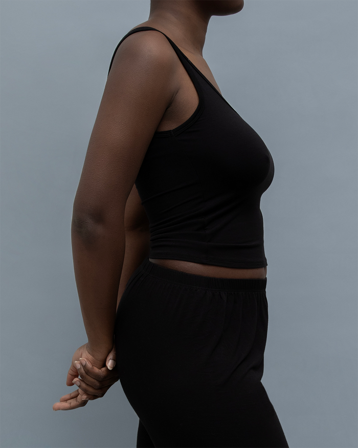 Side view of the Kye Recline Tank in black, showcasing its bamboo fabric and sleek scoop neck design. Kye Intimates’ sleeveless essential.